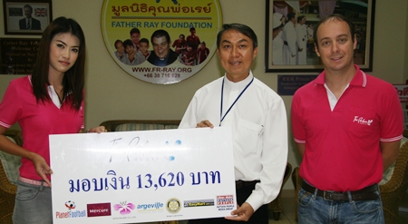 Oussaneeya Puekthong, left, and Jeremy Akoum, right, proprietors of The Perfume House, present a donation of 13,620 baht to Father Peter Srivorakul C.Ss.R., president of the Father Ray Foundation in Pattaya. The donation is the proceeds from an annual soccer competition which is organized by The Perfume House and won this year by the team from the Father Ray Children’s Home.